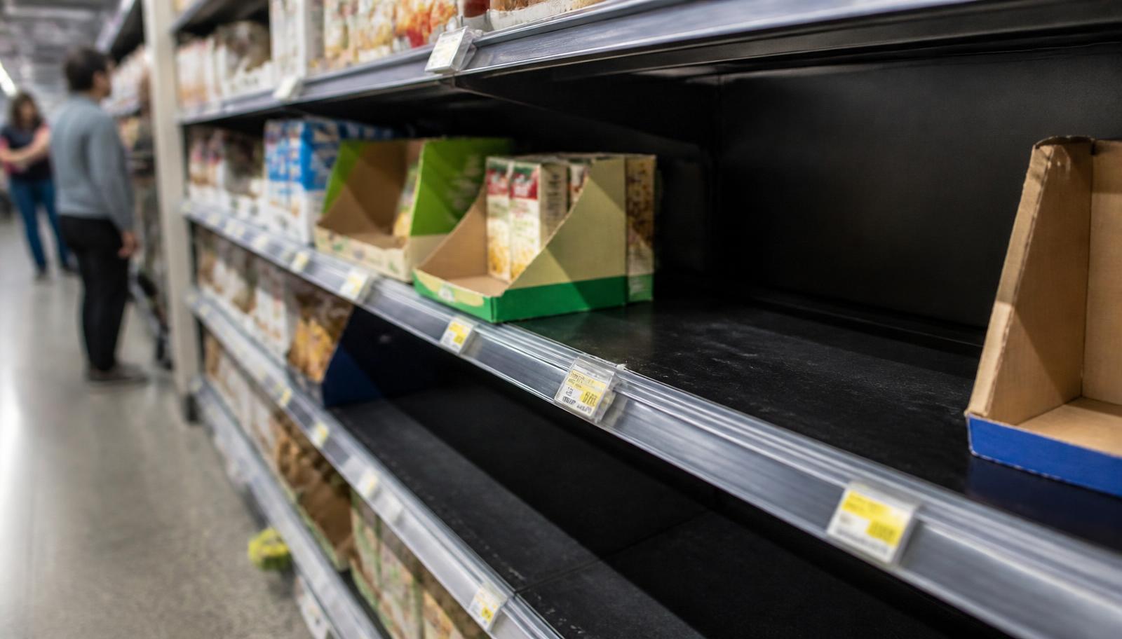 Gôndola de supermercado com espaços vazios entre os produtos, representando ruptura de estoque no varejo